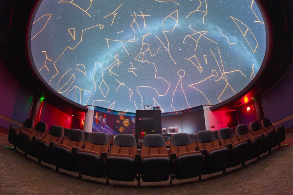 A photograph of the inside of the Emil Buehler Perpetual Trust Planetarium, with constellation lines displayed on the dome overhead.